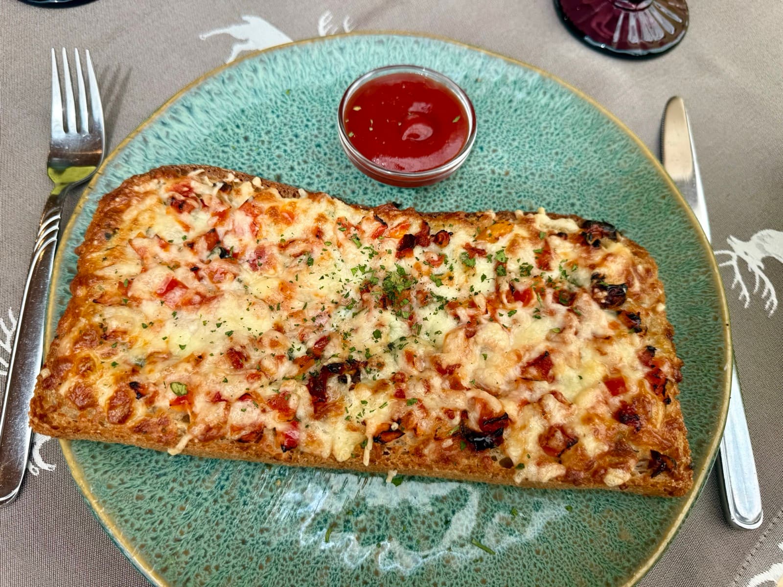 Toasted bread topped with tomatoes, melted mozzarella and herbs at Zentrum Café Restaurant