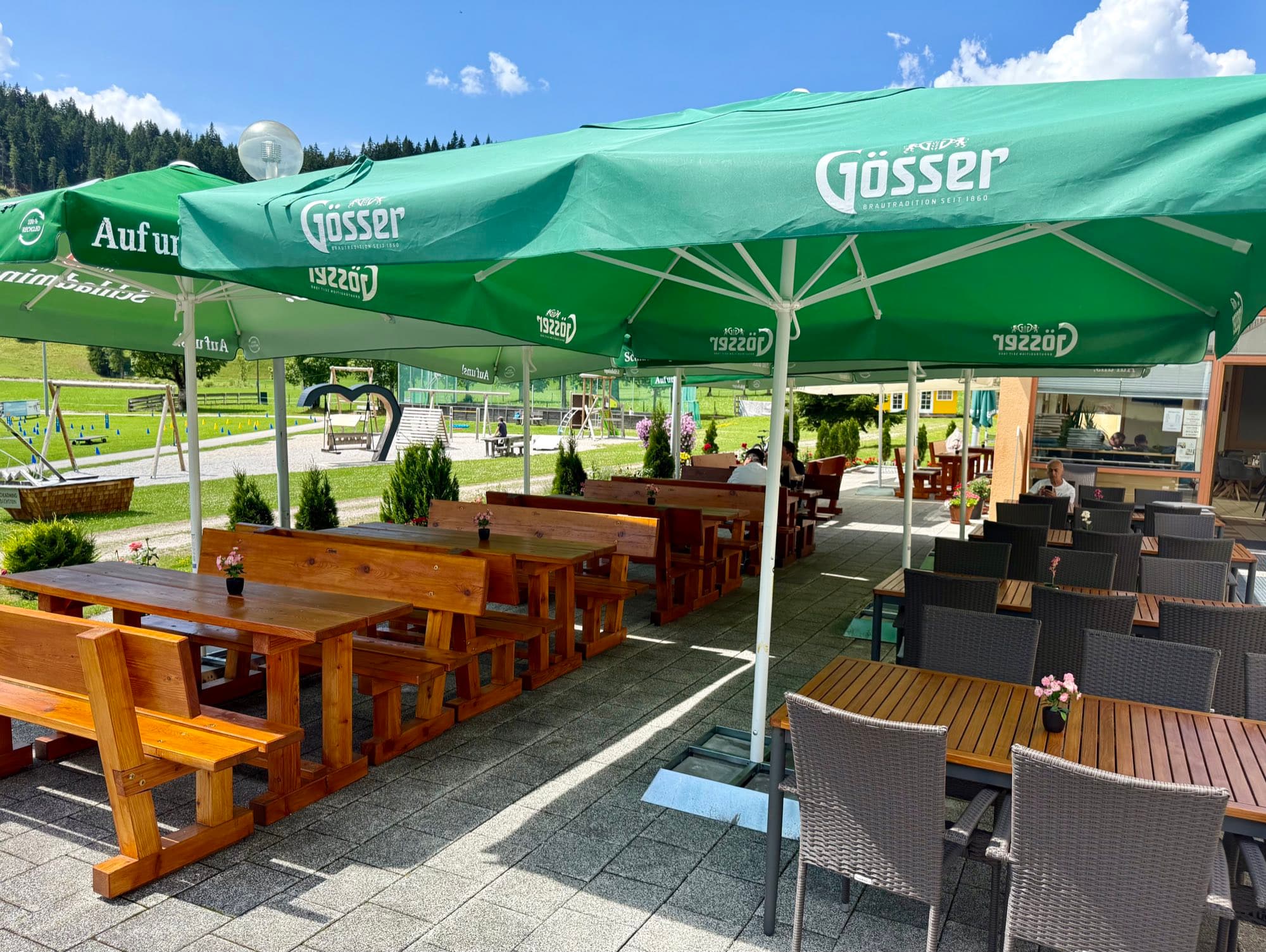 Wooden benches and tables on the terrace of Zentrum Café Restaurant on a sunny day